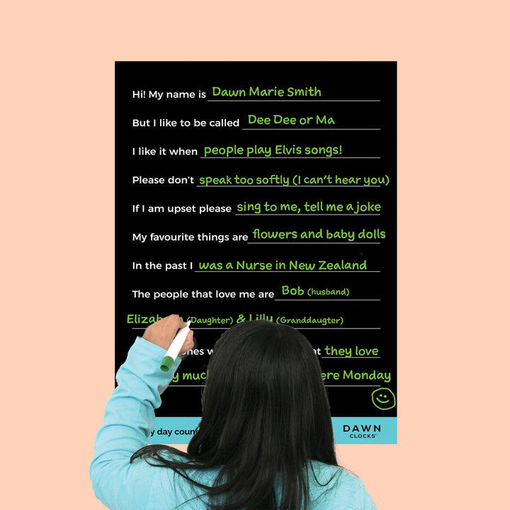 Dawn Clocks Care Poster for people living with disabilities and in shared care facilities like Aged care home. The picture shows a woman writing with a dry erase pen on the poster that has details about the person who is being cared for. Such as "Hi! My name is...." and "But I like to be called".