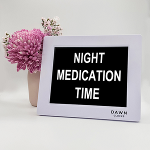 Original Dawn Clock shown on a table with the "Night medication time" reminder on the screen. This is ideal for all ages and proved essential for NDIS participants, people living with Dementia, people living with a disability and seniors.